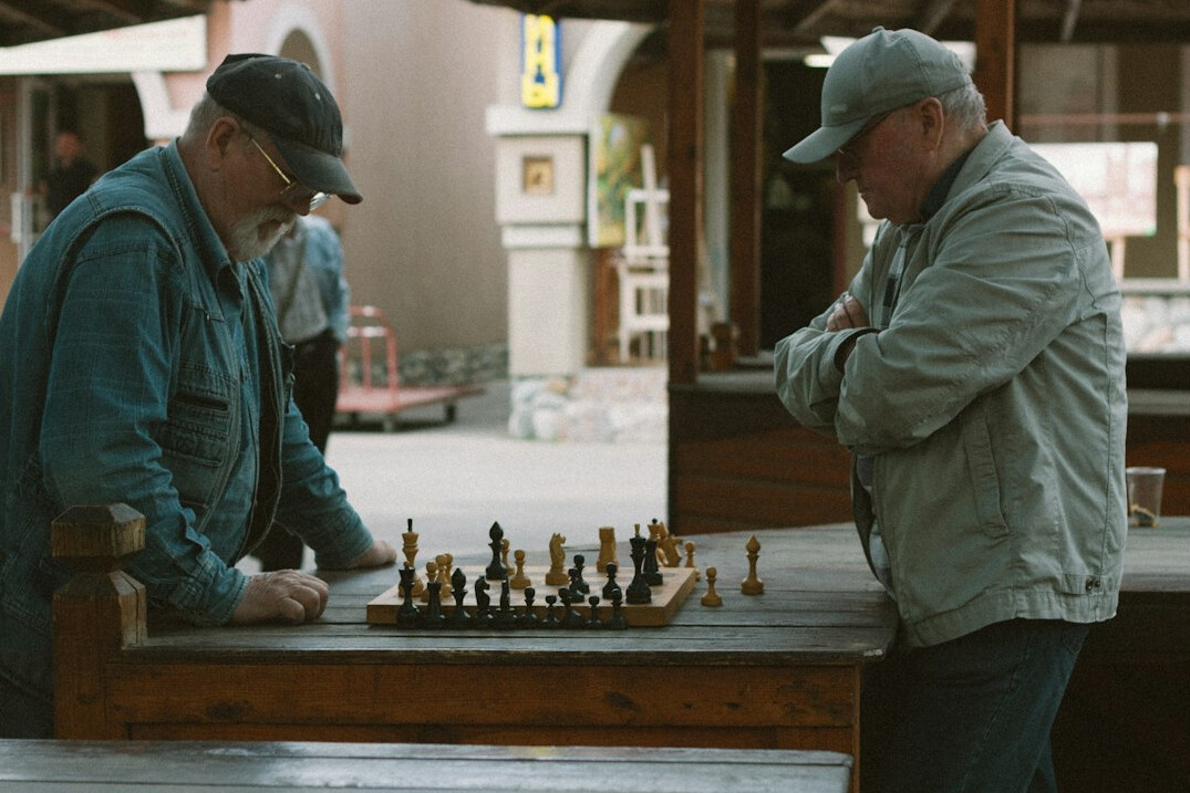 Two elderly men playing chess concentrating on the board