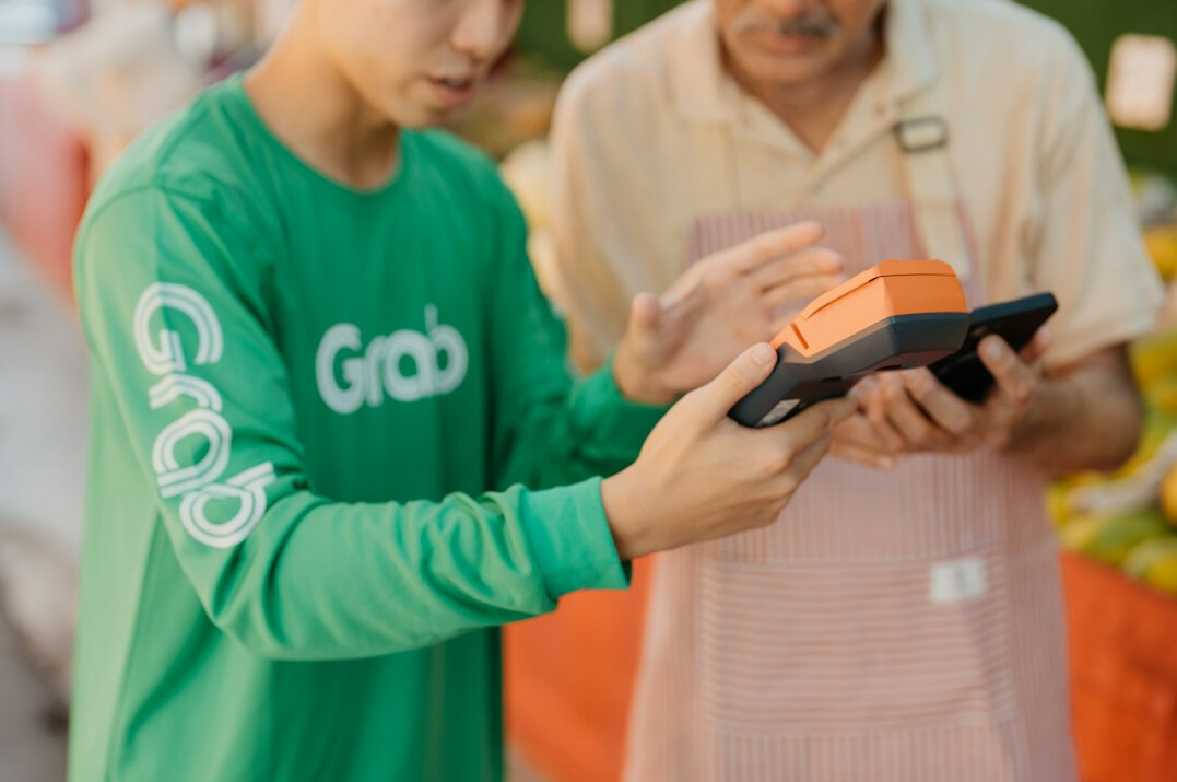 Young volunteer helping an elderly man with a tablet